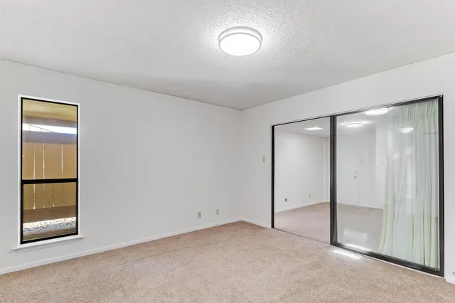 an empty room with windows and closet