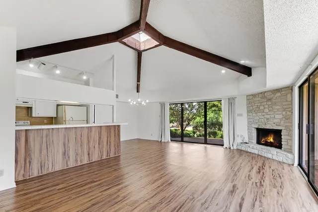 a view of a livingroom with wooden floor and a fireplace