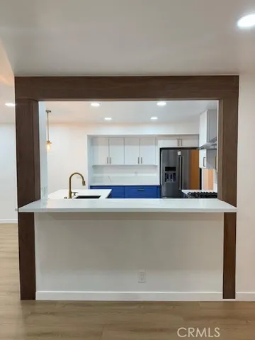 a kitchen with stainless steel appliances granite countertop a sink a stove and a refrigerator