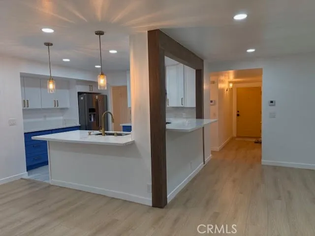 a large kitchen with stainless steel appliances a large counter top a stove a chimney a sink and a refrigerator