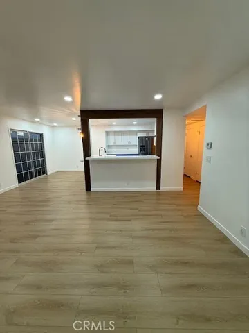 an empty room with wooden floor and a window