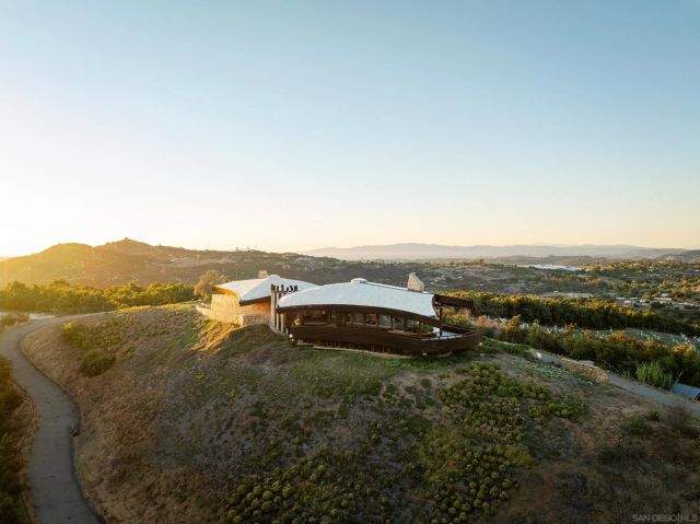 an aerial view of residential houses with outdoor space and trees