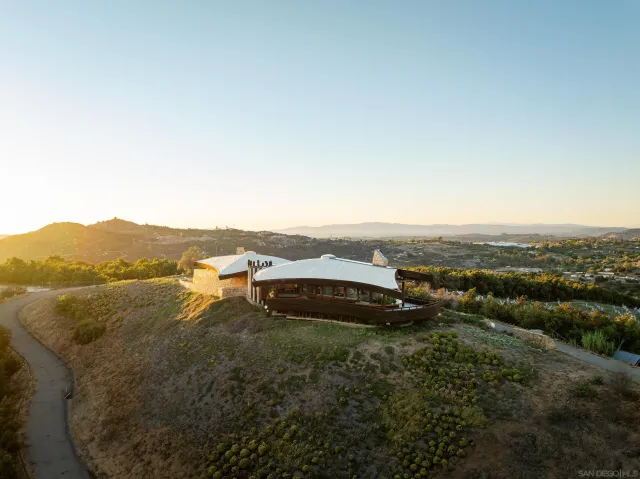 an aerial view of residential houses with outdoor space and trees