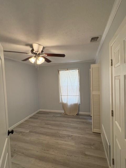 401 Reynolds Road Athens, TX 75751 - Photo 10 of 13 Bedroom featuring light gray wall paint, wood-finish flooring, white baseboards, crown molding, and a ceiling fan with light fixture