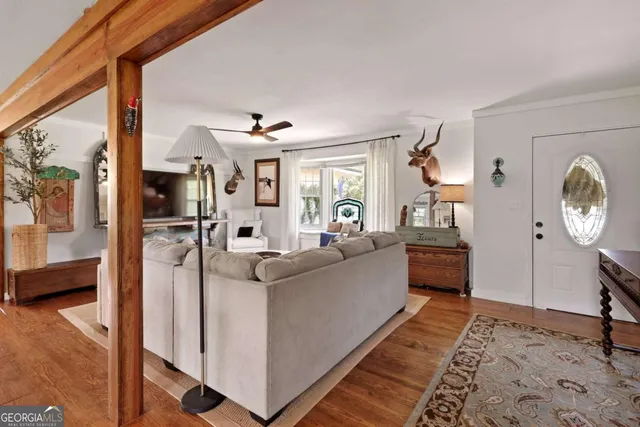 a living room with furniture a rug and wooden floor