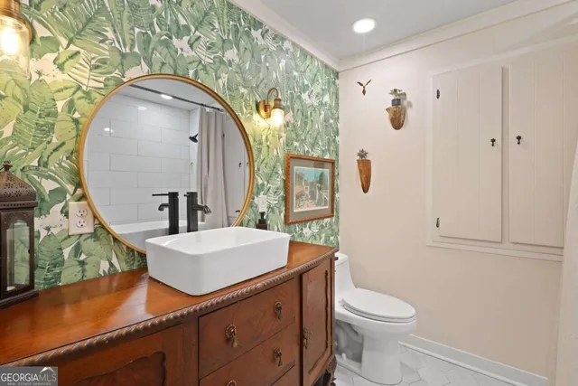 a bathroom with a sink a toilet and mirror