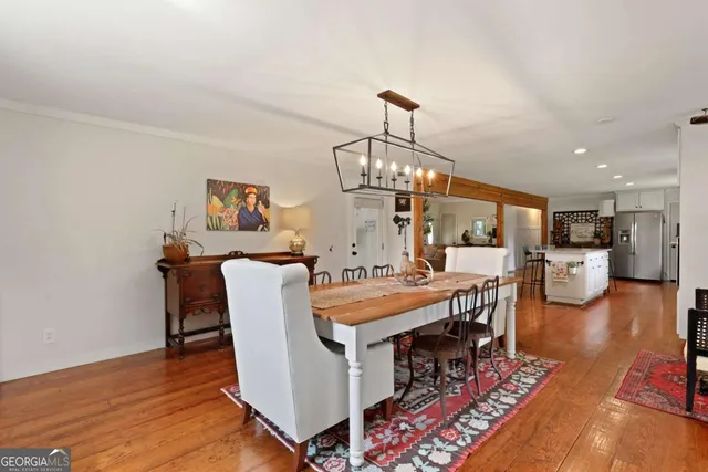 a dining room with furniture a chandelier and wooden floor