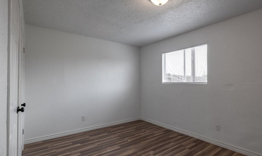 1010 Behmann Street Corpus Christi, TX 78418 - Photo 6 of 10 an empty room with wooden floor and windows