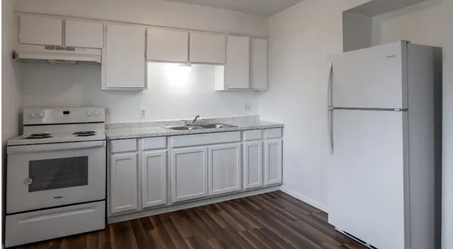 a kitchen with stainless steel appliances white cabinets and a refrigerator