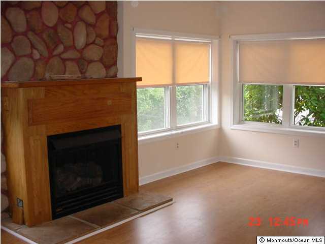 131 Mantoloking Road Brick, NJ 08723 - Photo 1 of 3 a living room with a fireplace and windows