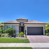 a front view of a house with a garden and palm tree