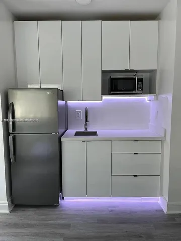 a kitchen with cabinets and white stainless steel appliances