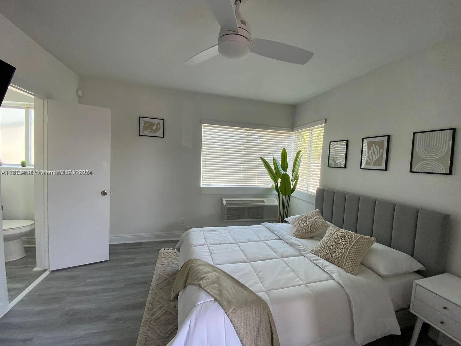 7325 Carlyle Avenue, Unit 12A Miami Beach, FL 33141 - Photo 4 of 7 a bedroom with a bed a dresser and a window