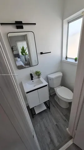 a bathroom with a toilet a sink and mirror