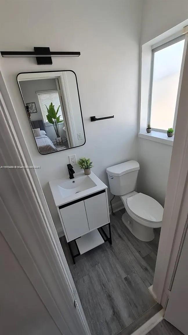 7325 Carlyle Avenue, Unit 12A Miami Beach, FL 33141 - Photo 5 of 7 a bathroom with a toilet a sink and mirror