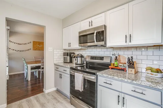 a kitchen with stainless steel appliances granite countertop a stove a sink and a microwave