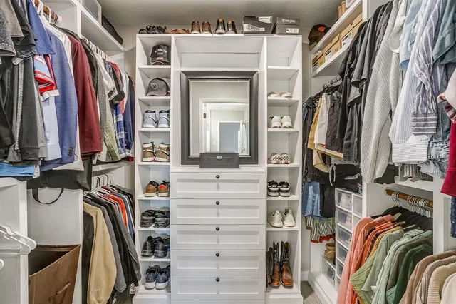 a view of walk in closet with clothes and shoes