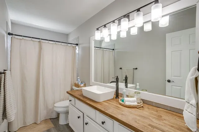a bathroom with a granite countertop sink toilet and a mirror