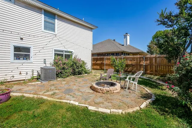 a backyard of a house with table and chairs