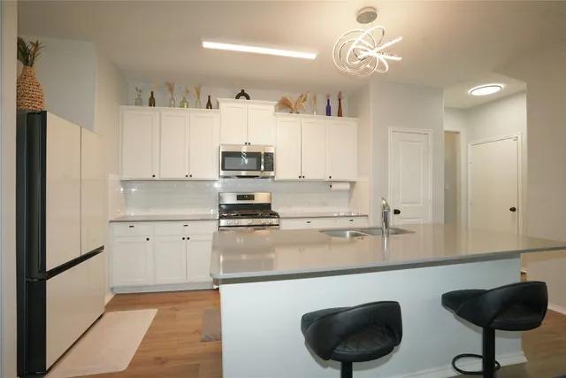 a kitchen with stainless steel appliances granite countertop a sink a stove a refrigerator and cabinets