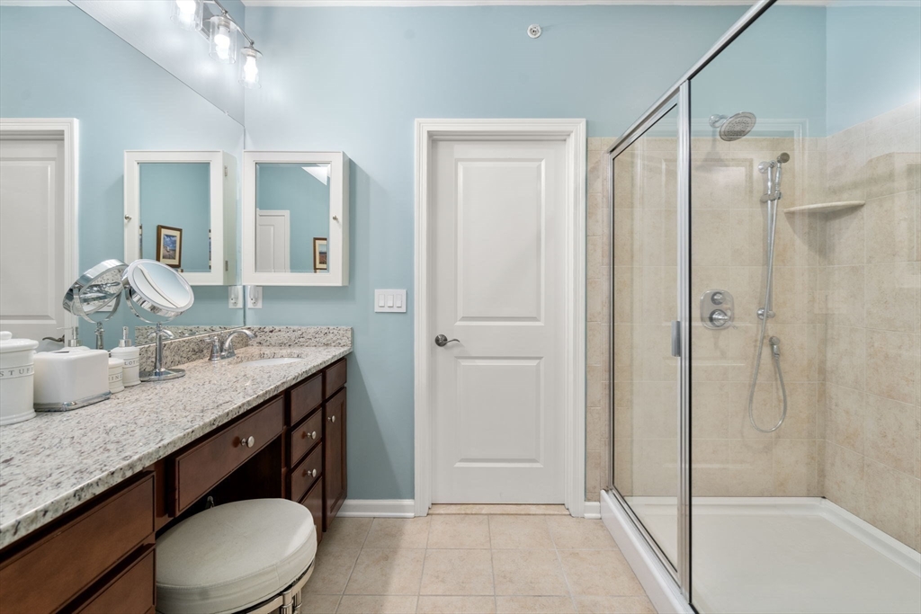 14 Iris Court, Unit 14 Canton, MA 02021 - Photo 18 of 42 a bathroom with a granite countertop sink toilet a mirror a vanity and shower