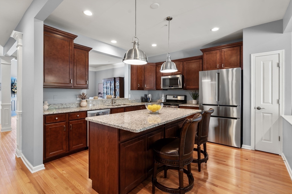14 Iris Court, Unit 14 Canton, MA 02021 - Photo 8 of 42 a kitchen with stainless steel appliances granite countertop a refrigerator a sink dishwasher a stove and a refrigerator with wooden floor