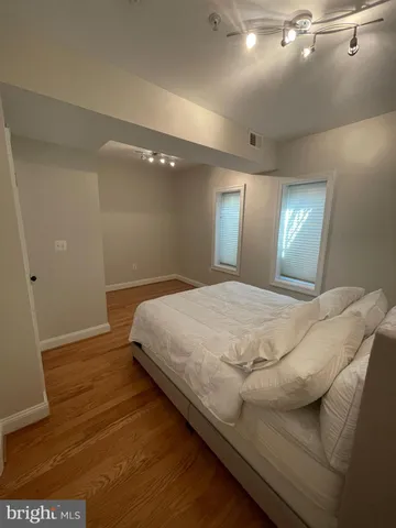 a bed sitting in a spacious bedroom next to a window