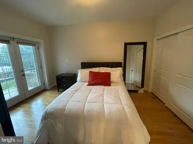 a bedroom with a bed and wooden floor