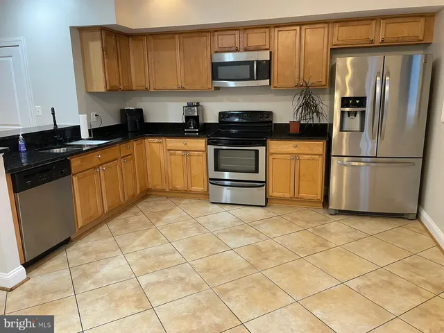 a kitchen with stainless steel appliances granite countertop a refrigerator sink and cabinets