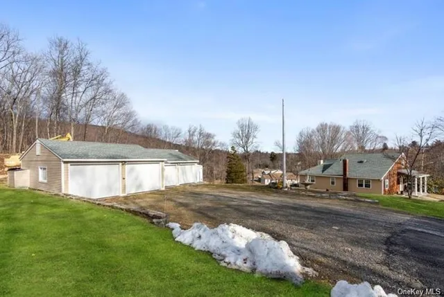a view of a house with a big yard and large trees