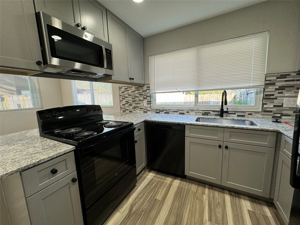 12804 Copper Cliff Avenue, Unit B Austin, TX 78727 - Photo 11 of 29 a kitchen with stainless steel appliances granite countertop a stove a sink and a microwave
