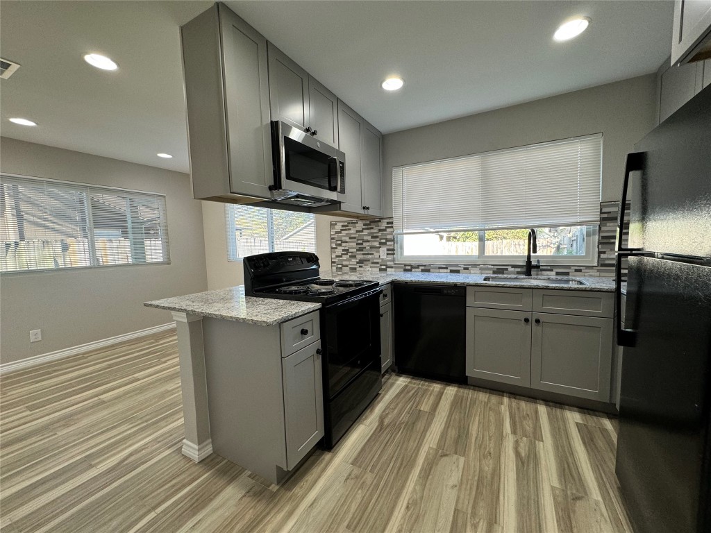 12804 Copper Cliff Avenue, Unit B Austin, TX 78727 - Photo 10 of 29 a kitchen with stainless steel appliances granite countertop a stove a sink and a microwave