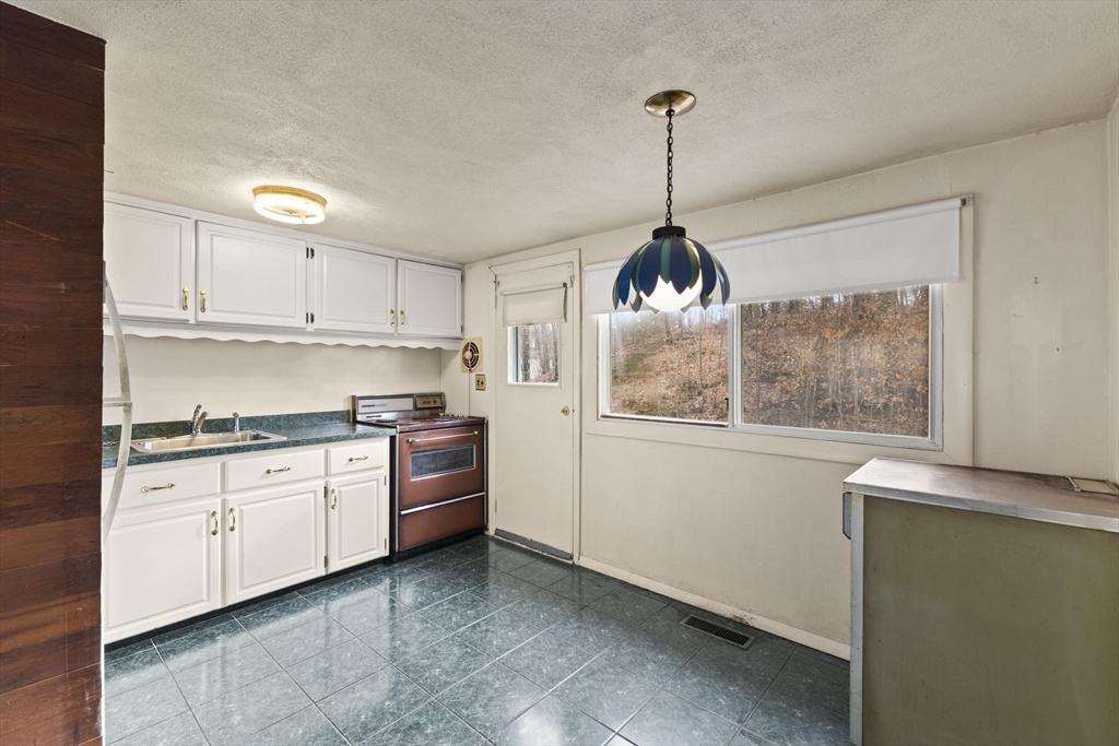 2 Alwin Street Boston, MA 02136 - Photo 17 of 43 a kitchen with granite countertop white cabinets and window