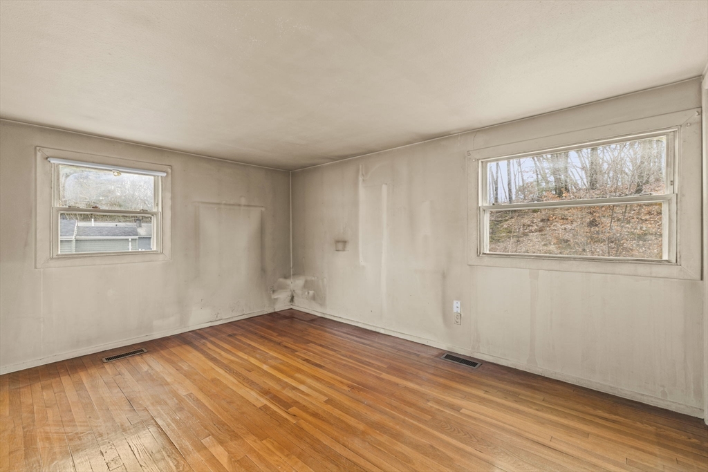 2 Alwin Street Boston, MA 02136 - Photo 19 of 43 a view of an empty room with wooden floor and a window