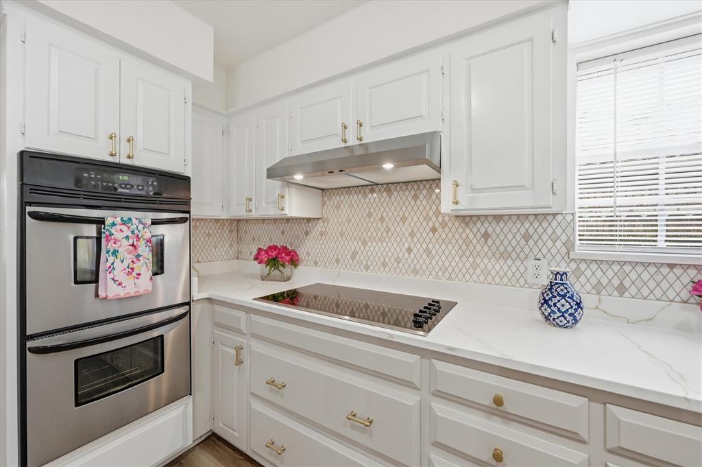 5808 Ridge Drive Arlington, TX 76016 - Photo 14 of 40 a kitchen with white cabinets a sink dishwasher and a stove with wooden floor