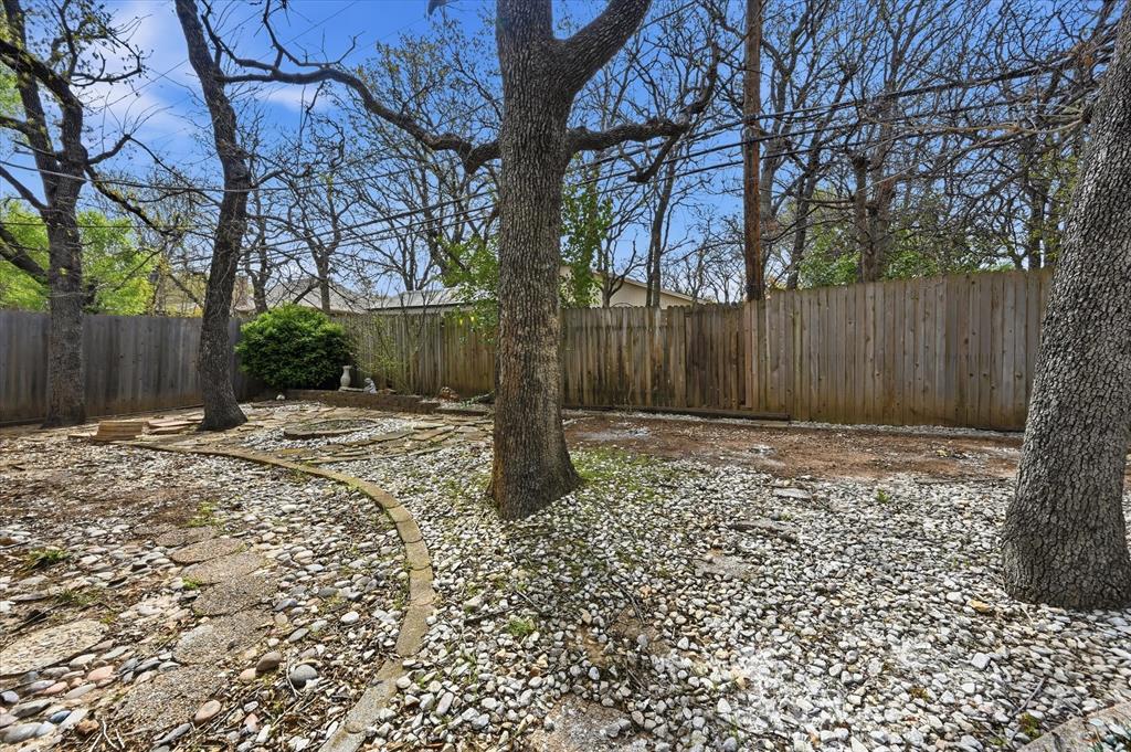 5808 Ridge Drive Arlington, TX 76016 - Photo 39 of 40 a view of a backyard with large trees and wooden fence