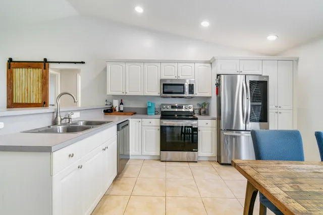 a kitchen with stainless steel appliances kitchen island granite countertop a refrigerator sink and stove