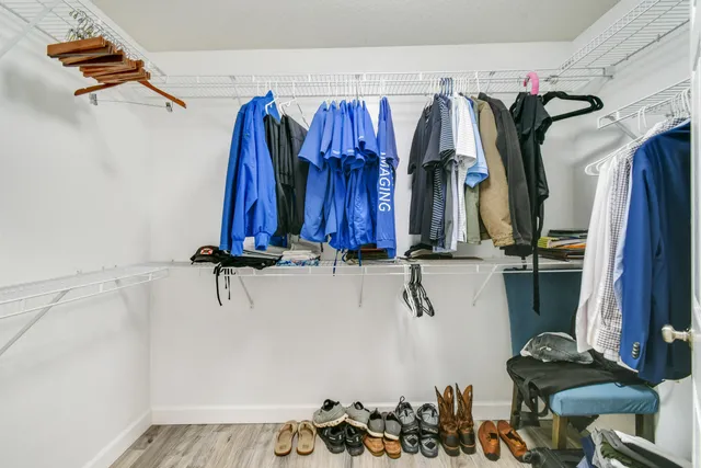 a view of walk in closet with clothes