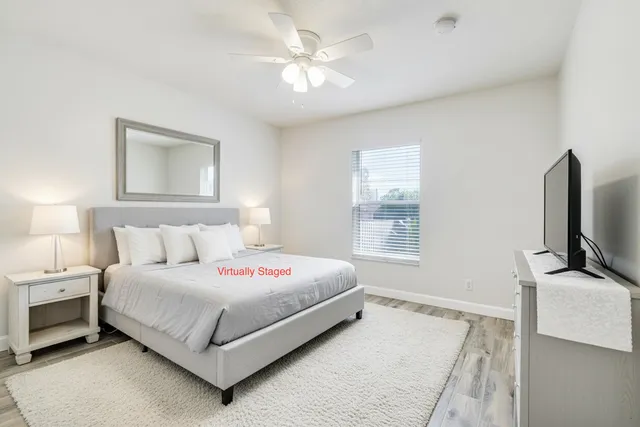 a bedroom with a bed flat screen tv and a window