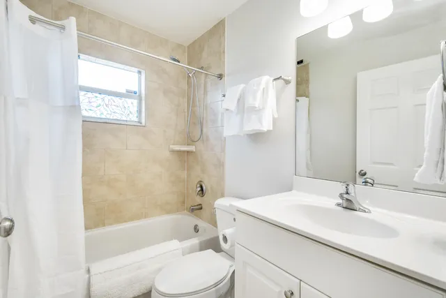 a bathroom with a granite countertop sink mirror toilet and bathtub