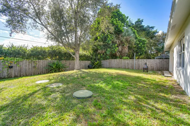 a view of a backyard with a small cabin and wooden fence