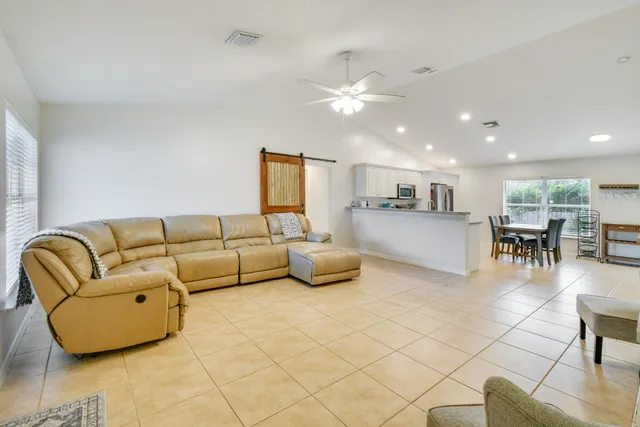a living room with furniture and kitchen view