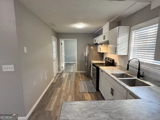 a kitchen with a sink and wooden floor