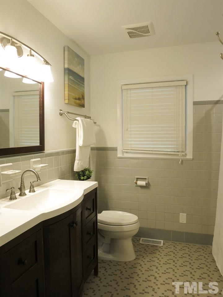 105 Dartmouth Road Raleigh, NC 27609 - Photo 20 of 25 The 2 Bedrooms share the updated Hall Bath w/tiled tub/shower, newer vanity-sink, mirror, light fixture, hardware & faucet.