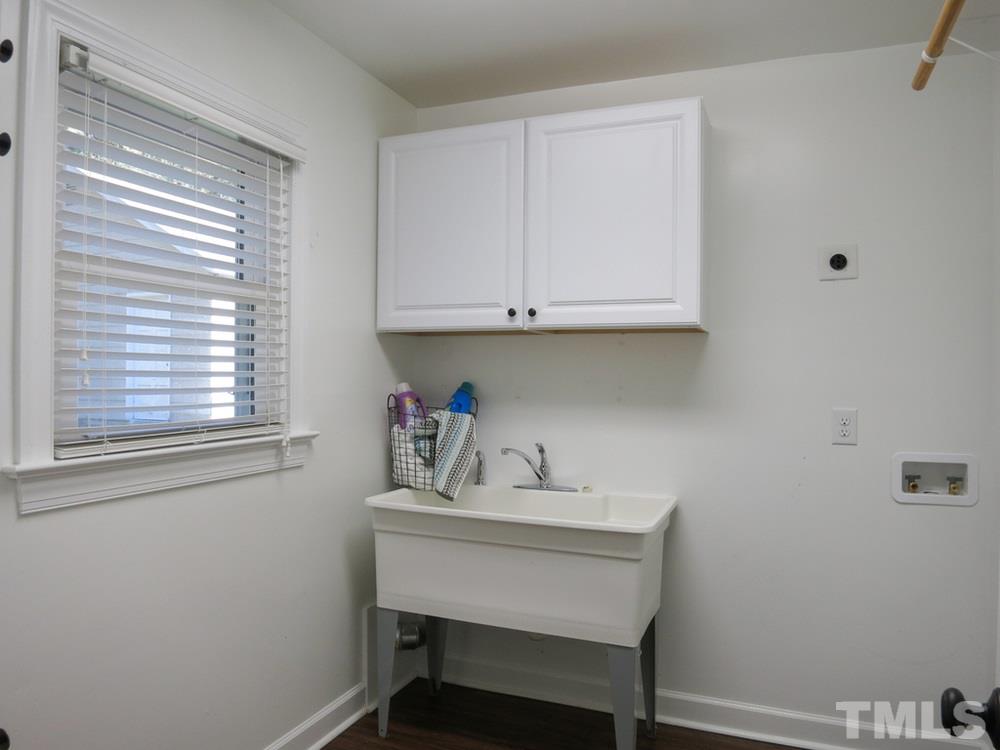105 Dartmouth Road Raleigh, NC 27609 - Photo 21 of 25 The bright Laundry Rm features a tall linen cabinet, shelf w/hanging rod & wall cabinets over the huge utility sink (great for dog washing!).