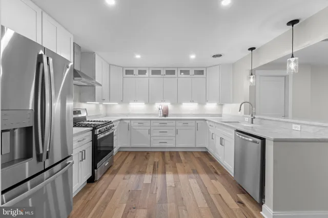 a large kitchen with lot of wooden cabinets and stainless steel appliances