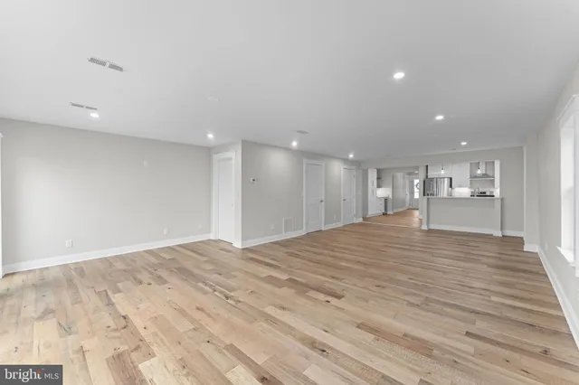 a view of a room with wooden floor and white walls