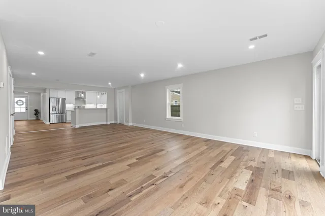 a view of a hallway with a white walls and wooden floor