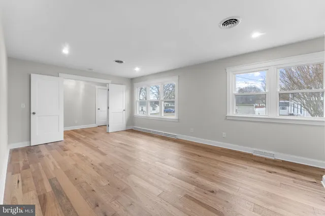 a spacious bathroom with a double vanity sink toilet mirror and shower