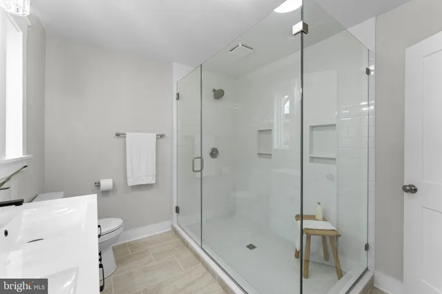 a bathroom with a bathtub shower sink vanity and toilet